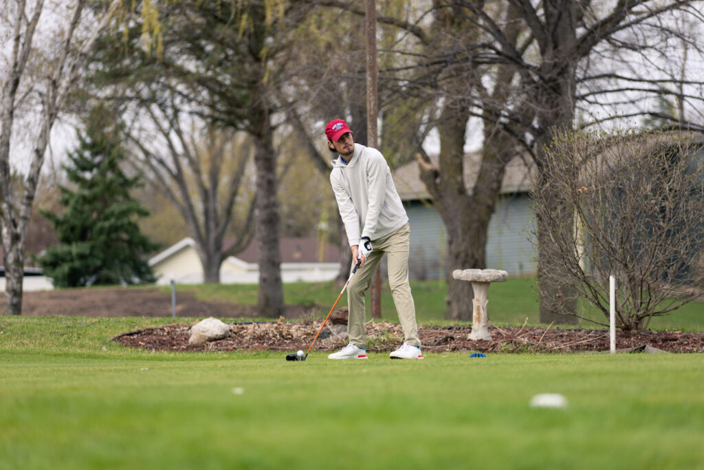 St. John's golfer preparing to hit golf ball off of a tee.